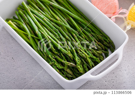 Blanched young asparagus in a baking pan 113866506