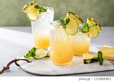 Variety of pineapple and lime cocktails or mocktails, mai tai, refreshing drinks idea 113866961