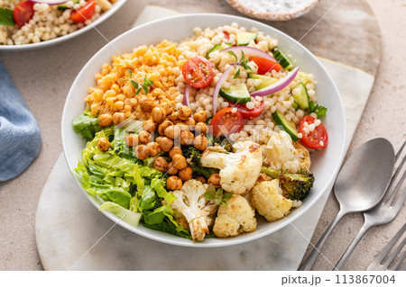 Vegan lunch bowl with roasted vegetables, fresh lettuce, cooked lentils, couscous salad and roasted chickpeas 113867004