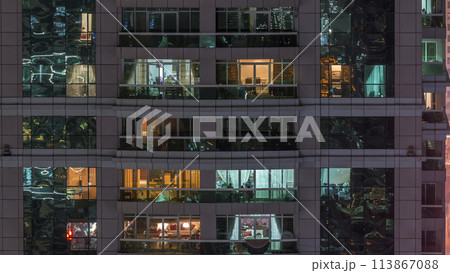 Night view of exterior apartment building timelapse. High rise skyscraper with blinking lights in windows 113867088