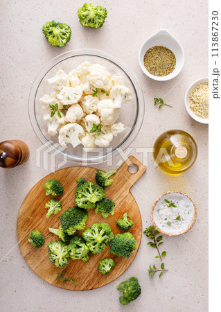 Cooking with broccoli and cauliflower, getting ready to roast vegetables with spices and olive oil 113867230