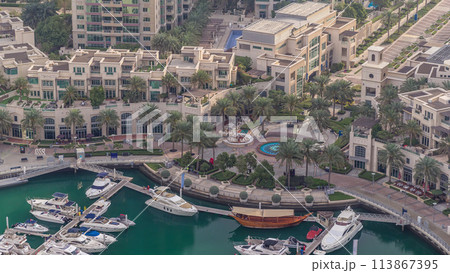 Aerial view on yachts floating in Dubai marina timelapse. White boats are in green canal water. Aerial view on yachts floating in Dubai marina timelapse. White boats are in green canal water. 113867395