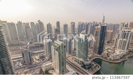 Aerial top view of Dubai Marina morning timelapse. Modern towers and traffic on the road 113867397