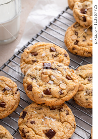 Chocolate chip cookies on a cooling rack with flaky salt served with milk Chocolate chip cookies on a cooling rack with flaky salt served with milk 113867725