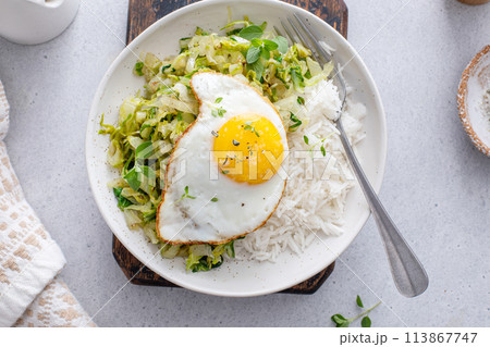 Sauteed green cabbage or lettuce with fried egg, healthy breakfast idea Sauteed green cabbage or lettuce with fried egg, healthy breakfast idea 113867747