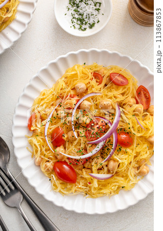 Spaghetti squash with chickpeas and tomatoes topped with red onion, low carb vegan recipe idea 113867853