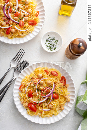 Spaghetti squash with chickpeas and tomatoes topped with red onion, low carb vegan recipe idea 113867855