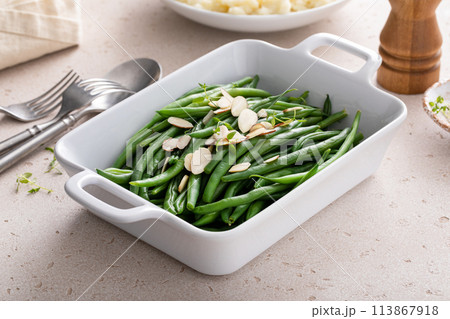 Green beans topped with almonds in a baking dish, traditional side dish for dinner or celebration Green beans topped with almonds in a baking dish, traditional side dish for dinner or celebration 113867918