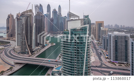 Aerial view of Dubai Marina residential and office skyscrapers with waterfront day to night timelapse 113868017