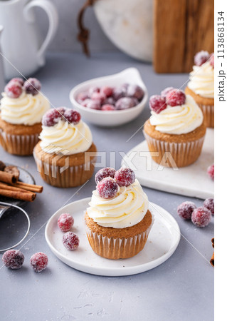 Spiced Christmas cupcakes with cream cheese frosting with sugared cranberries 113868134