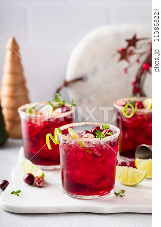 Christmas cranberry and lime margarita cocktail garnished with lime zest 113868224