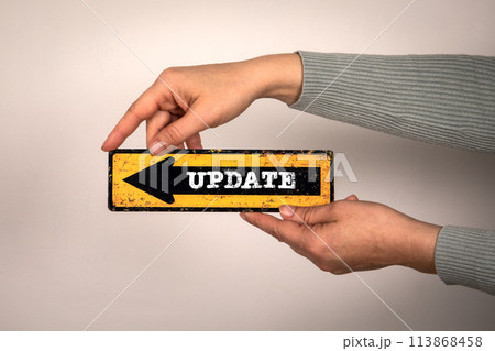 Update Concept. Pointing arrow with text in hands on white background 113868458
