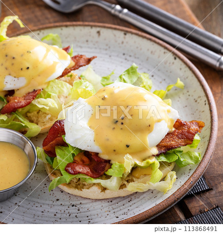 Eggs Benedict with bacon and lettuce on english muffins Eggs Benedict with bacon and lettuce on english muffins 113868491