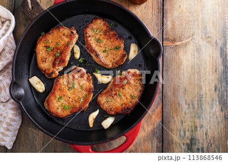 Pork chops cooked in a cast iron pan 113868546