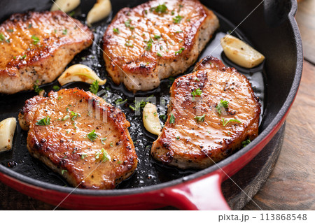 Pork chops cooked in a cast iron pan 113868548