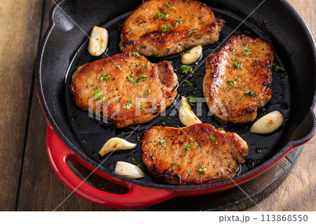 Pork chops cooked in a cast iron pan 113868550