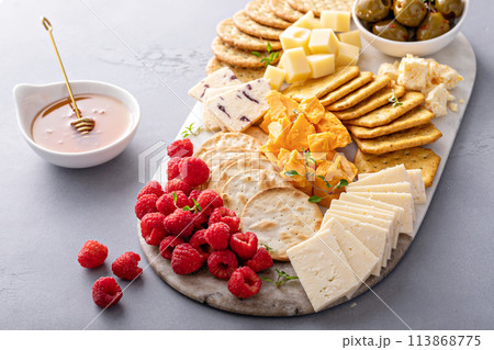 Cheese board or snack board with crackers, cheese, olives and berries Cheese board or snack board with crackers, cheese, olives and berries 113868775