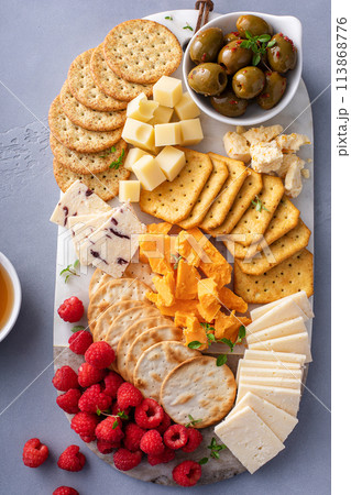 Cheese board or snack board with crackers, cheese, olives and berries Cheese board or snack board with crackers, cheese, olives and berries 113868776