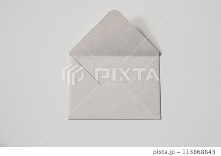 Close-up neutral textured paper envelope on beige background. Flat lay with copy space, top view. Mailing concept. Craft blank mockup for lettering, greeting card, postcard, invitation. No people. Close-up neutral textured paper envelope on beige background. Flat lay with copy space, top view. Mailing concept. Craft blank mockup for lettering, greeting card, postcard, invitation. No people. 113868843