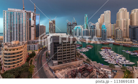 Luxury yachts parked on the pier in Dubai Marina bay with city aerial view timelapse 113869183