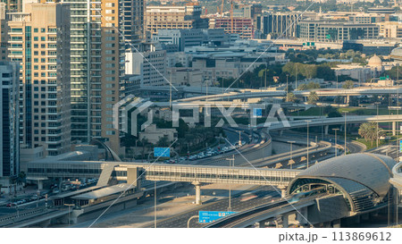 Futuristic building of Dubai metro and tram station and luxury skyscrapers behind timelapse 113869612
