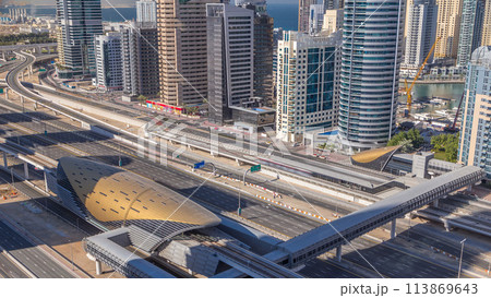 Futuristic building of Dubai metro and tram station and luxury skyscrapers behind timelapse Futuristic building of Dubai metro and tram station and luxury skyscrapers behind timelapse 113869643
