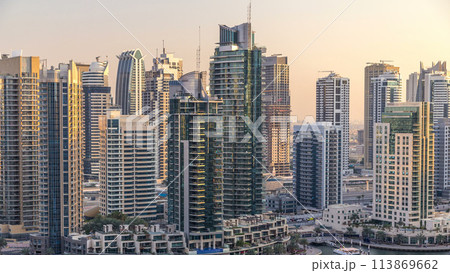 Beautiful aerial view of Dubai Marina promenade and canal with floating yachts and boats before sunset in Dubai, UAE. Beautiful aerial view of Dubai Marina promenade and canal with floating yachts and boats before sunset in Dubai, UAE. 113869662