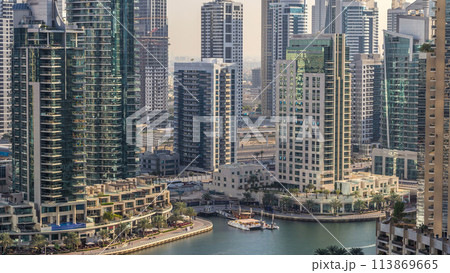 Beautiful aerial view of Dubai Marina promenade and canal with floating yachts and boats before sunset in Dubai, UAE. Beautiful aerial view of Dubai Marina promenade and canal with floating yachts and boats before sunset in Dubai, UAE. 113869665