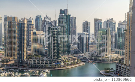 Beautiful aerial view of Dubai Marina promenade and canal with floating yachts and boats before sunset in Dubai, UAE. Beautiful aerial view of Dubai Marina promenade and canal with floating yachts and boats before sunset in Dubai, UAE. 113869666