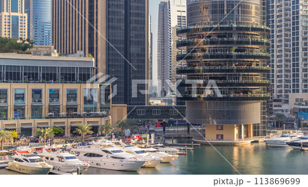 Aerial view of Dubai Marina with shopping mall, restaurants, towers and yachts timelapse, United Arab Emirates. Aerial view of Dubai Marina with shopping mall, restaurants, towers and yachts timelapse, United Arab Emirates. 113869699