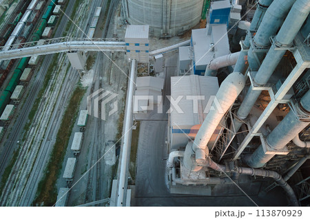 Cement plant with high factory structure and tower cranes at industrial production area. Manufacture and global industry concept Cement plant with high factory structure and tower cranes at industrial production area. Manufacture and global industry concept 113870929