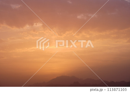 Dramatic bright red sky with orange-gray th.underclouds at sunset over a dark mountain forest landscape at golden hour 113871103