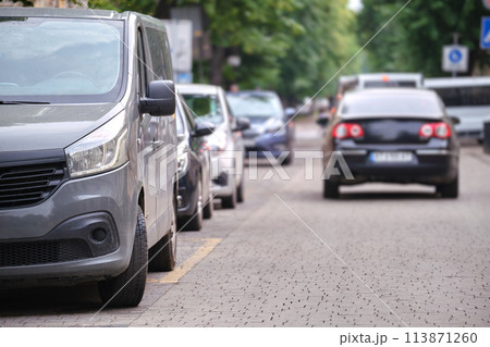 City traffic with cars parked in line on street side City traffic with cars parked in line on street side 113871260