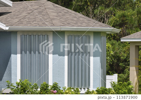 Steel storm shutters for hurricane protection of house windows. Protective measures before natural disaster in Florida 113871900