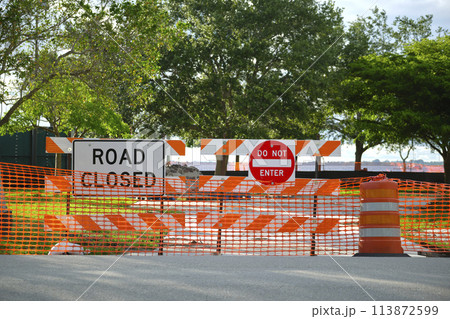Road closed at construction site with protective fence barrier Road closed at construction site with protective fence barrier 113872599