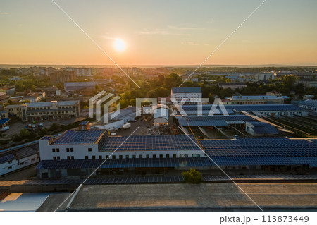 Aerial view of blue photovoltaic solar panels mounted on industrial building roof for producing green ecological electricity. Production of sustainable energy concept Aerial view of blue photovoltaic solar panels mounted on industrial building roof for producing green ecological electricity. Production of sustainable energy concept 113873449