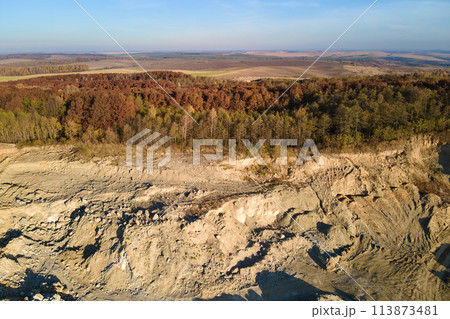 Aerial view of open pit mining site of limestone materials for construction industry with excavators and dump trucks 113873481