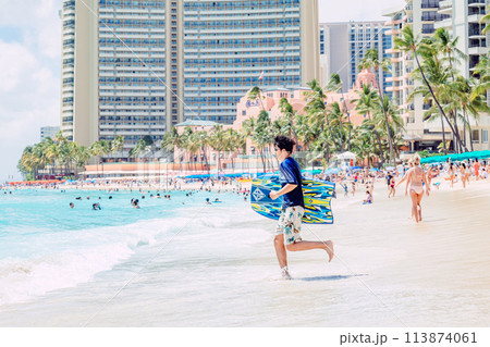 ハワイ、ワイキキビーチで海に向かって走る男性 ハワイ、ワイキキビーチで海に向かって走る男性 113874061
