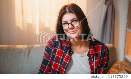 Smart woman. Smiling portrait. Positive attitude. Cheerful casual female student in spectacles sitting sunny light room interior. 113875299
