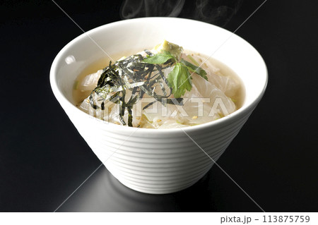 三つ葉、刻み海苔、わさびが乗った出汁入り熱々鯛茶漬けを黒背景で撮影 113875759