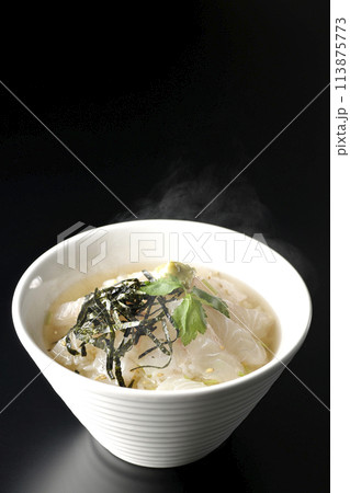 三つ葉、刻み海苔、わさびが乗った出汁入り熱々鯛茶漬けを黒背景で撮影 113875773