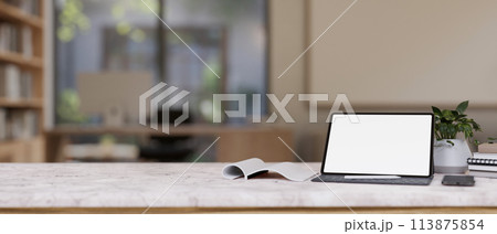 The white marble table showcases a white-screen digital tablet and decor in a contemporary office. 113875854