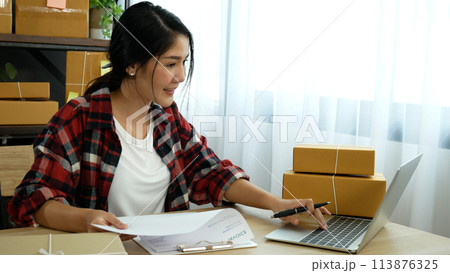 Online seller Close up hands Young asian woman typing laptop keyboard checking online order, check goods stock delivery package shipping postal. Asian woman startup small business at home office Online seller Close up hands Young asian woman typing laptop keyboard checking online order, check goods stock delivery package shipping postal. Asian woman startup small business at home office 113876325