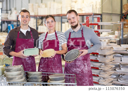 Team of successful professional artisans with handcrafted pottery in workshop 113876350