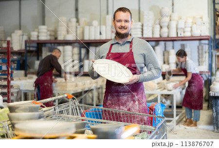 Young man posing with ceramic dishes 113876707