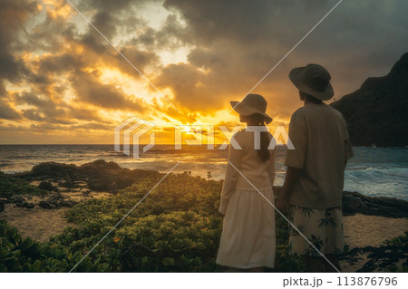 ハワイ、マカプウで朝日を眺める若い男女 113876796
