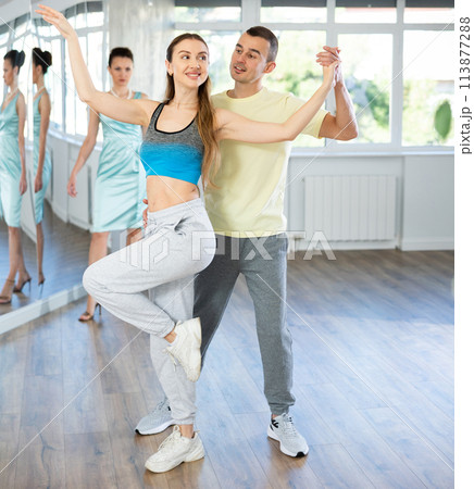 Smiling woman enjoying merengue with man in latin dance class 113877288