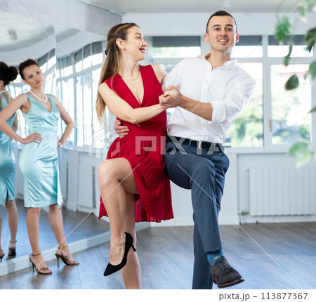 Couple in stage costumes learns boogie woogie dancing during individual lesson 113877367