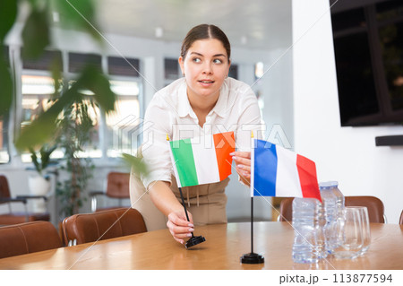 Young woman puts flags of Italy and France on table Young woman puts flags of Italy and France on table 113877594