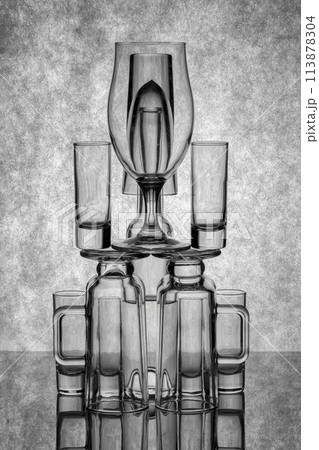 Still life with glassware on a reflective surface 113878304